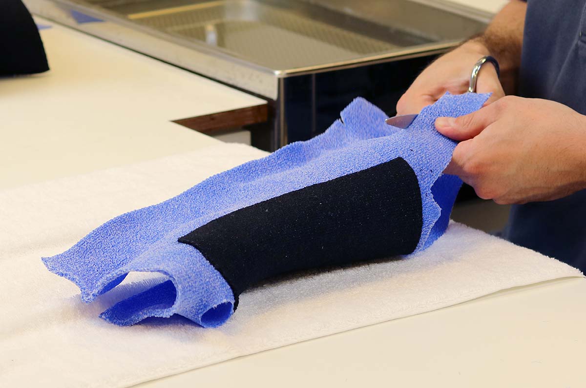 Trimming excess material of an Orficast More 30 cm orthosis.