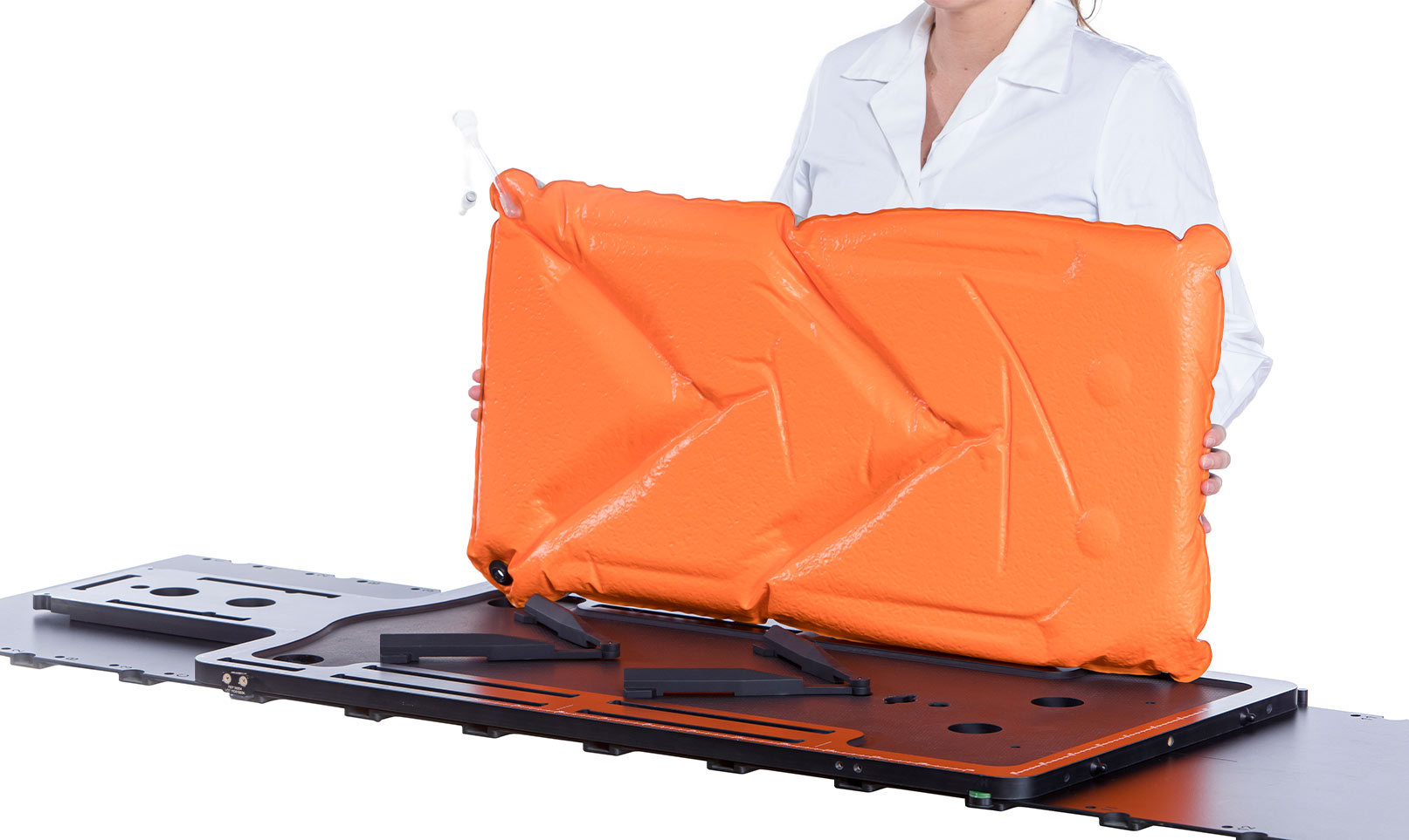 Woman holding an Orange Orfit Vacuum Bag over a baseplate with two indexing bars.